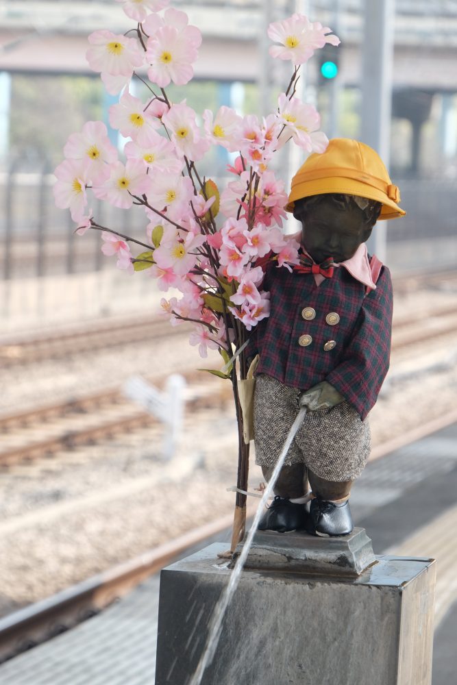 little peeing monk statue boy tokyo japan cherry blossoms 667x1000