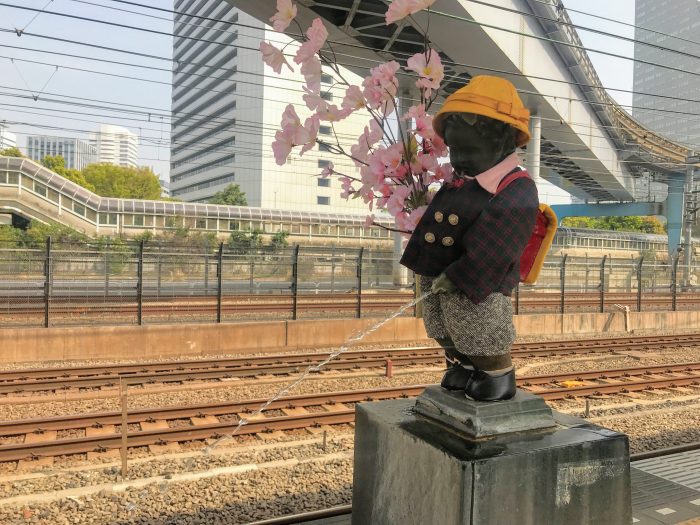 little peeing monk statue boy tokyo japan train station 700x525
